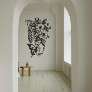 Cuadro de silueta anatómica con flores y mariposa, arte decorativo moderno en negro, diseño simbólico de transformación para pared.